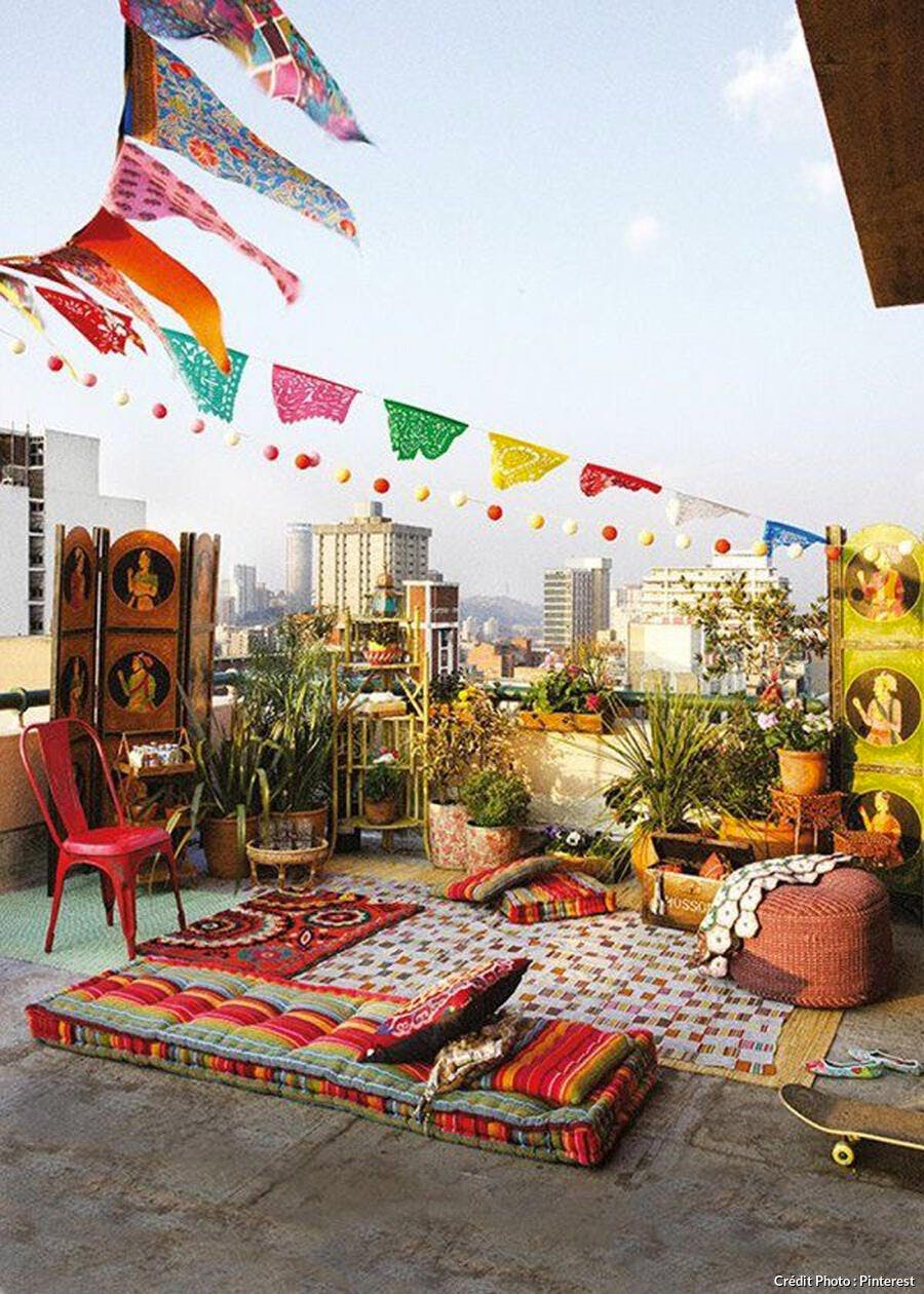 Balcon au style baba cool avec matelas colorés au sol et fanions suspendus