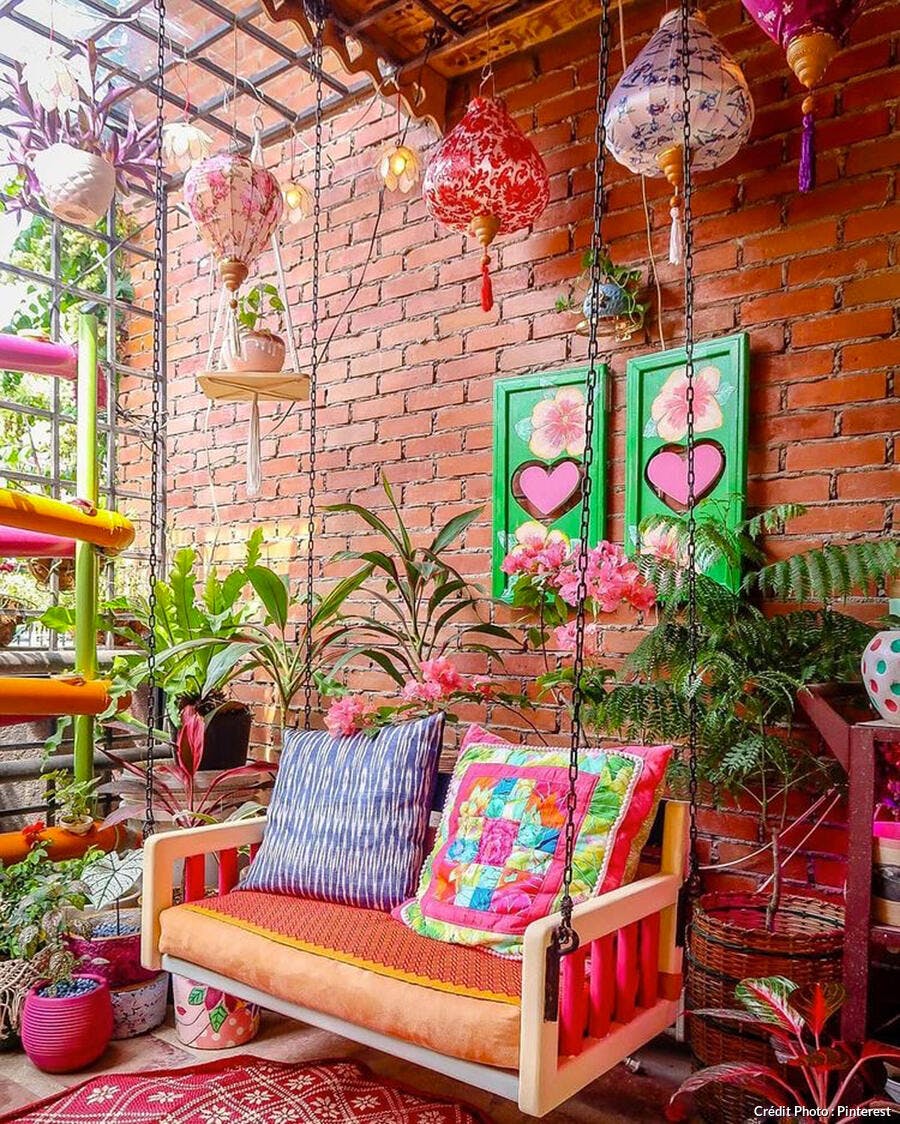 Balcon alternatif aux lanternes, plantes vertes et fauteuils colorés