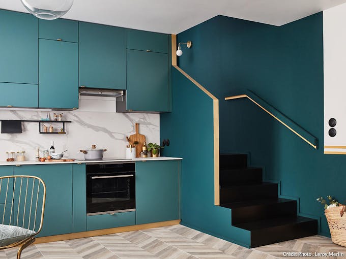 une cuisine bleu et or avec escalier intégré