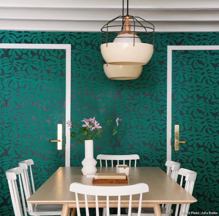 Portes avec tapisserie verte à motifs végétaux.