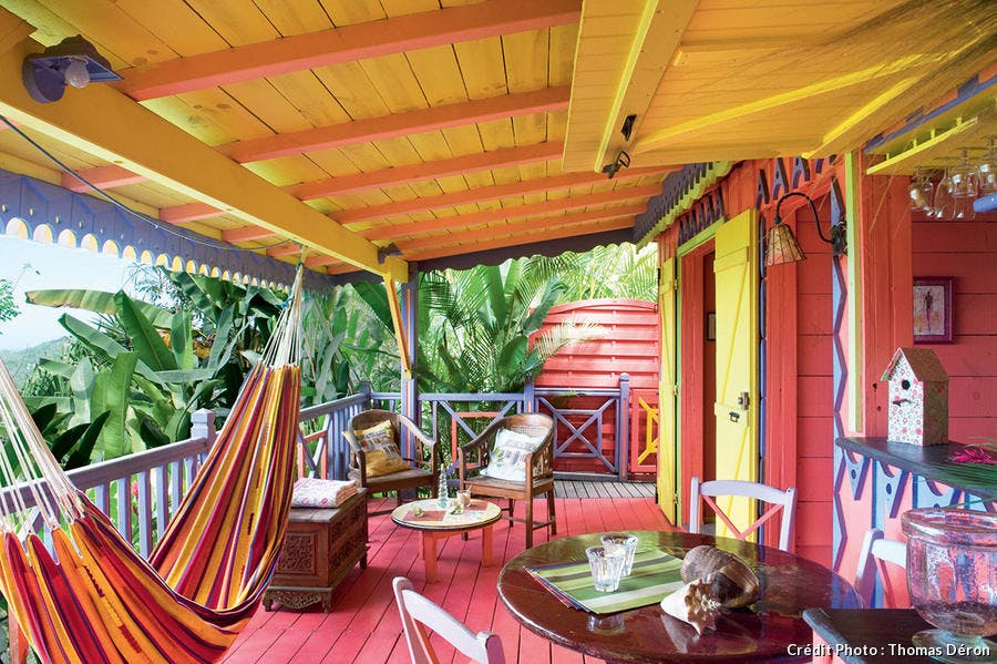 Terrasse colorée avec hamacs suspendus.
