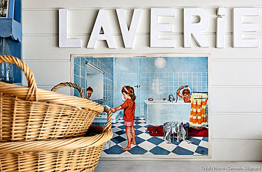 Mot laverie courant sur un mur, au dessus d'une illustration vintage.