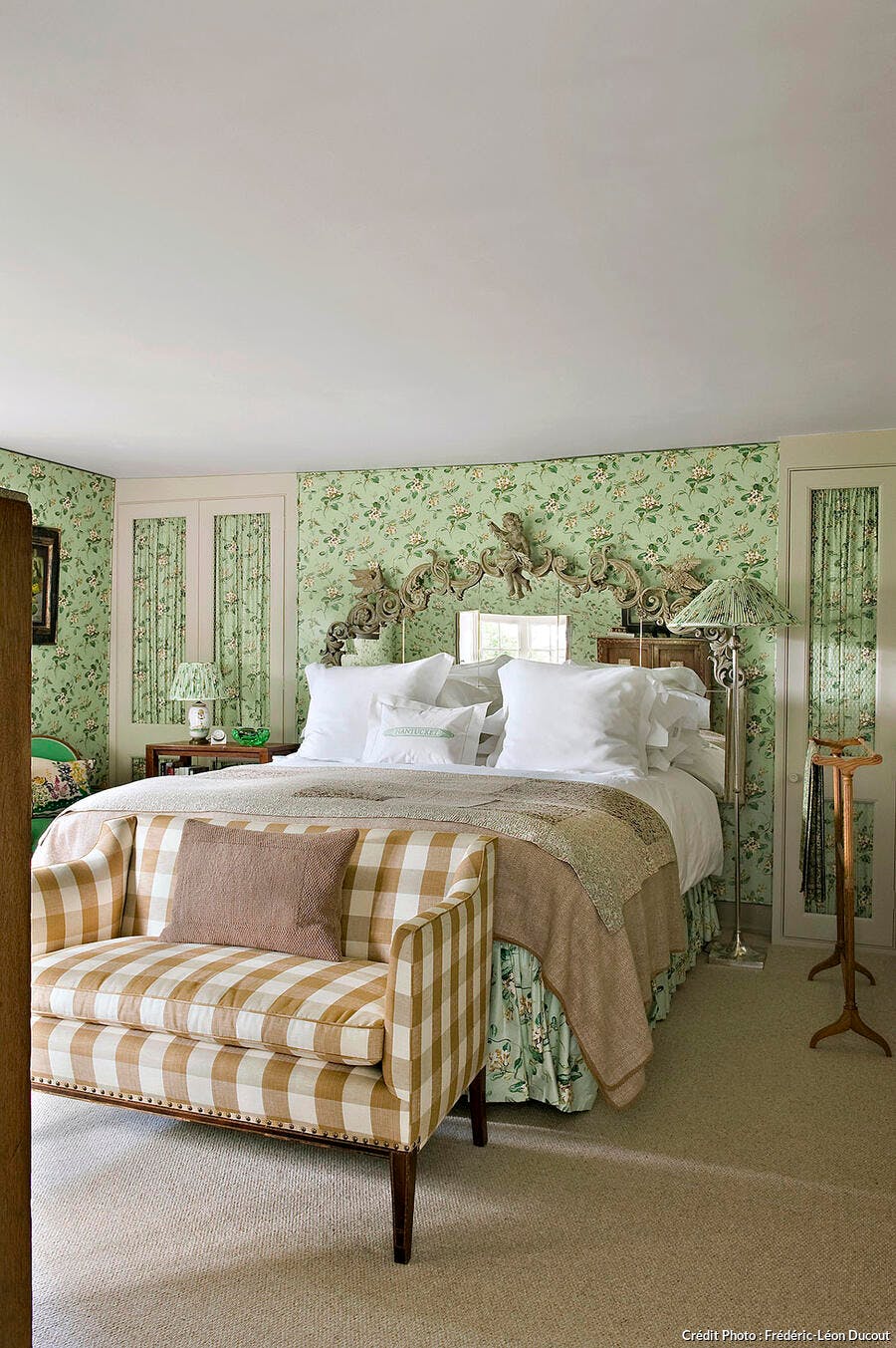 Chambre verte avec papier peint à motifs fleuris.