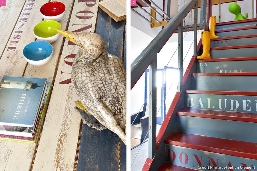 Oiseau de mer sur une table en bois, marches d'un escalier rouge et gris avec lettrage.