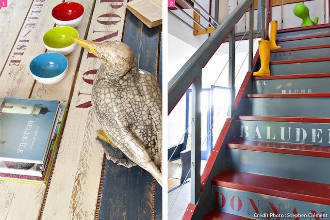 Oiseau de mer sur une table en bois, marches d'un escalier rouge et gris avec lettrage.