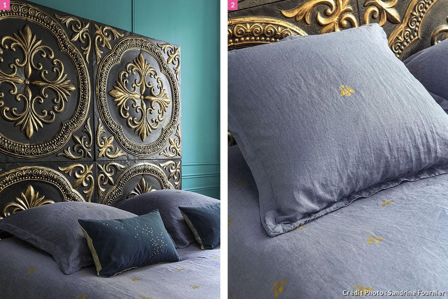 Tête de lit avec dorures, motifs inspiré de la royauté comme le Lys. Oreillers.