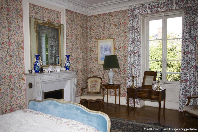 Chambre au style classique du XVIIIème siècle, papier peint à motif fleuris.
