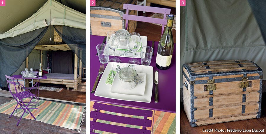 Lit en bambou, table violette et coffre de voyage.