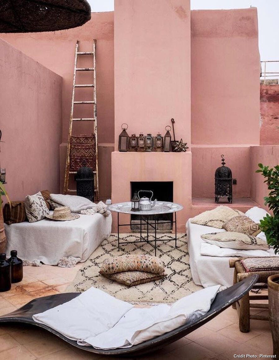 Terrasse à l'inspiration marocaine avec tapis berbère et mur couleur terracotta