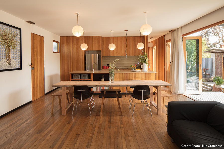 une salle à manger avec cuisine ouverte entièrement habillée de bois