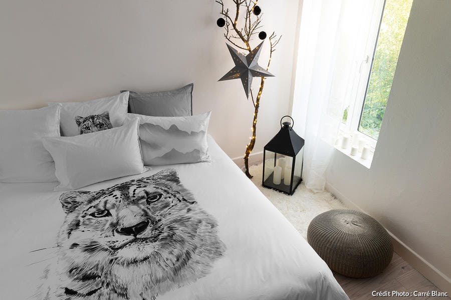une chambre à coucher avec une housse de couette imprimée d'une tête de tigre