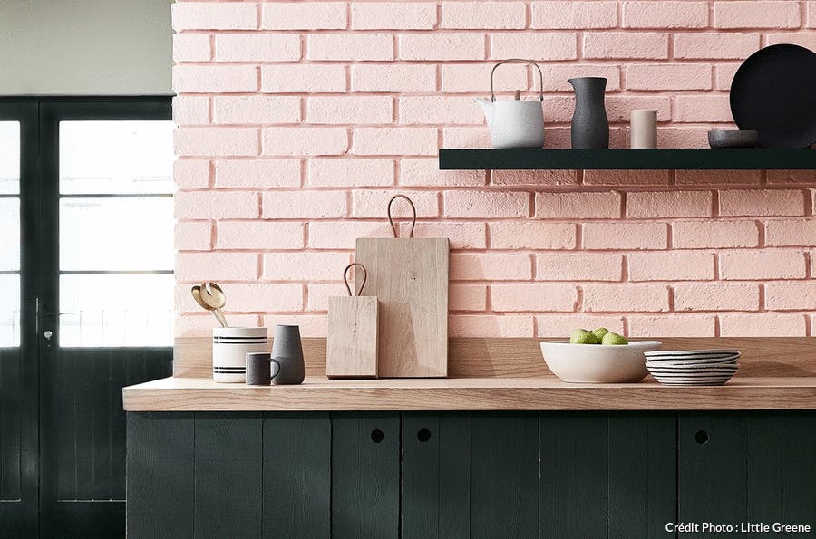 une cuisine en bois noir avec des briques roses