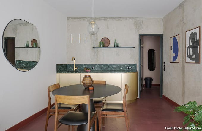 une cuisine dorée avec une crédence et un plan de travail en marbre vert