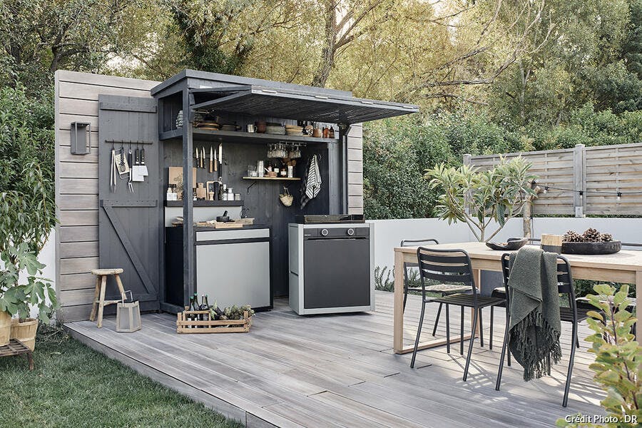 une salle à manger et une cuisine d'extérieur modulaire inspirée par l'esprit food truck dans un jardin