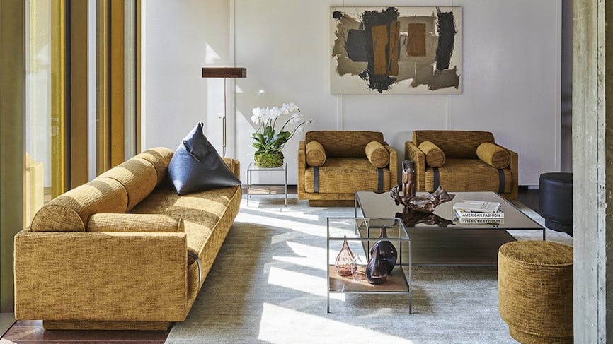 un salon de style arty meublé avec élégance, notamment un canapé et des fauteuils sanglés
