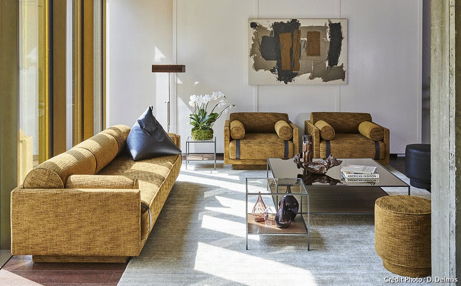 un salon de style arty meublé avec élégance, notamment un canapé et des fauteuils sanglés 