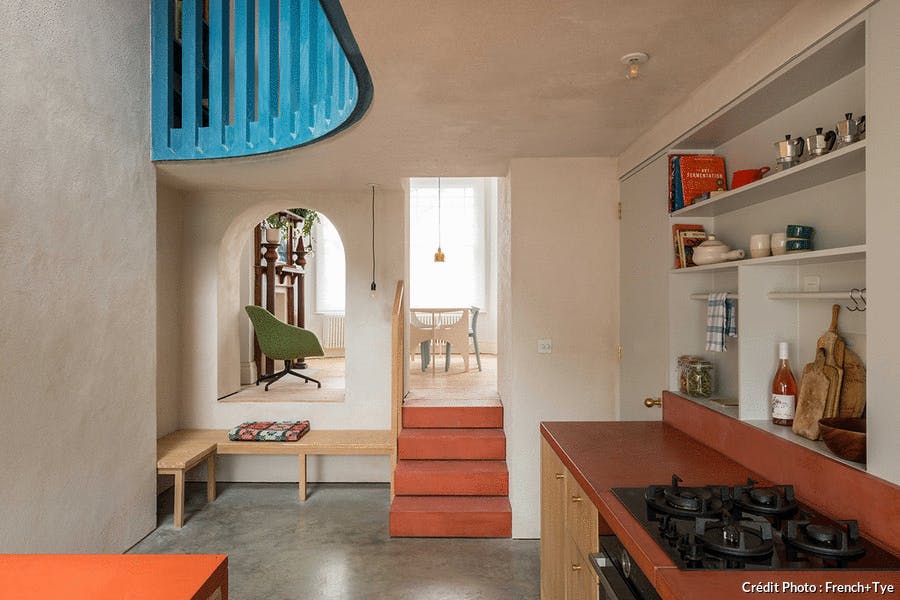 Une cuisine colorée dans une extension en bois minimaliste.