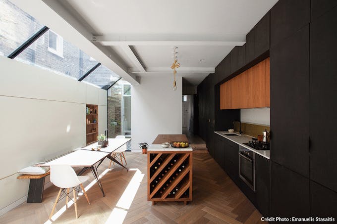 une pièce à vivre contemporaine avec cuisine ouverte sous un plafond de verre