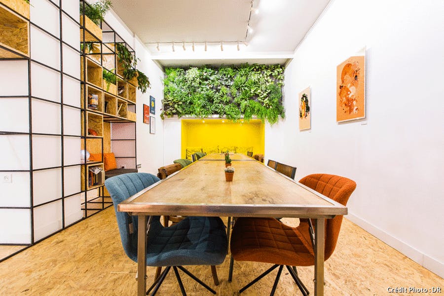 une salle de réunion avec un mur végétal et une niche jaune