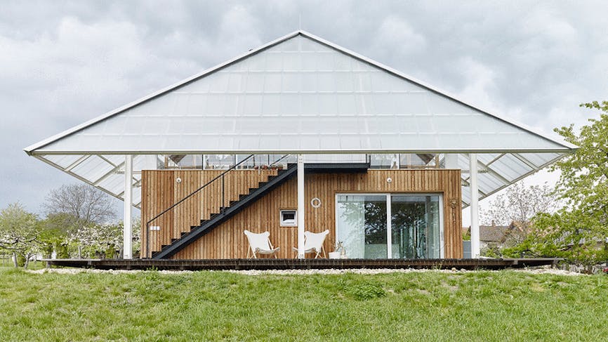 une maison moderne en bois coiffée d'une serre