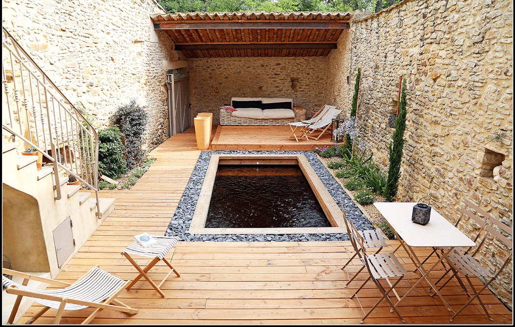 une mini piscine avec une terrasse en bois dans une maison de campagne