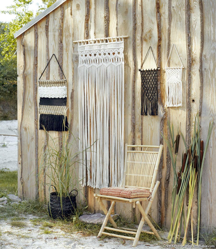 Accessoires en crochet beiges et noirs sur mur en bois.