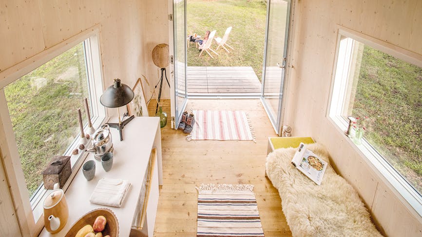 l'intérieur d'une tiny house avec cuisine ouverte et tapis rayés au sol