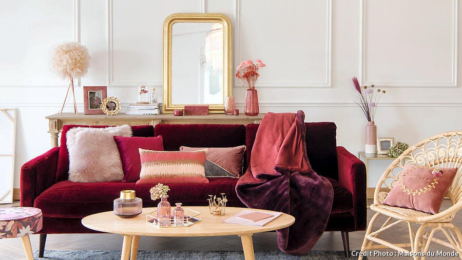 Un salon ambiance boudoir avec canapé en velours et objets en laiton