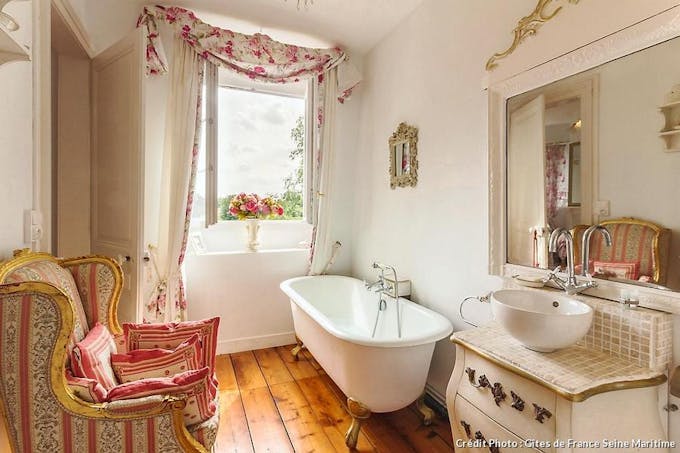 Salle de bains rose et blanche et baignoire à pattes de lion