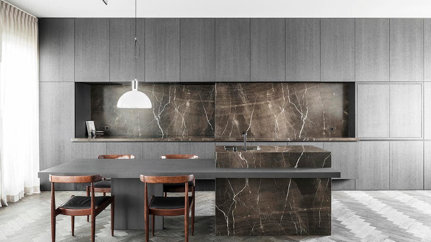 une cuisine design et épurée en marbre noir et chaises vintage