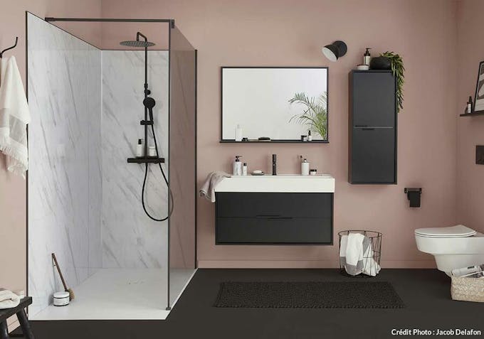 une salle de bains. contemporaine avec douche habillée de marbre et une colonne de douche noire mate