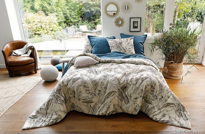 une chambre à coucher ouverte sur l'extérieur avec du linge de lit végétal