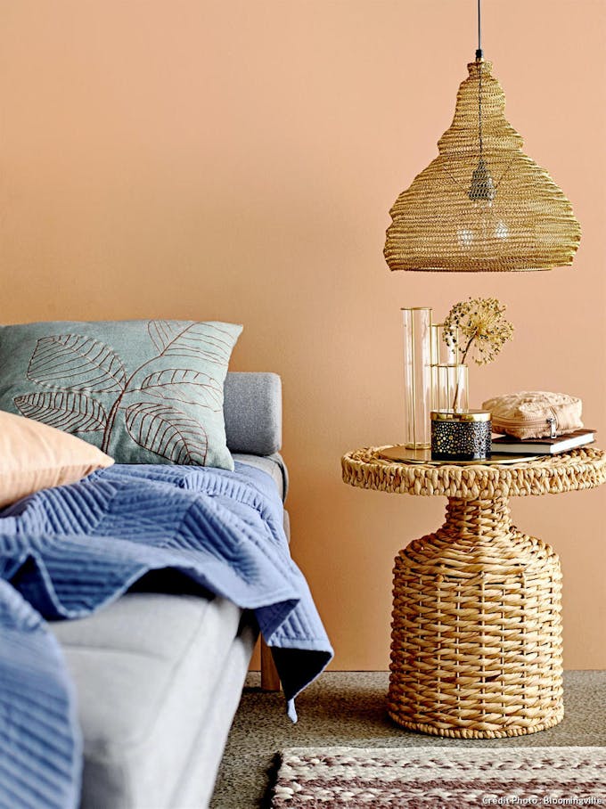 Coin cosy avec canapé, table d'appoint et suspension en fibres naturelles