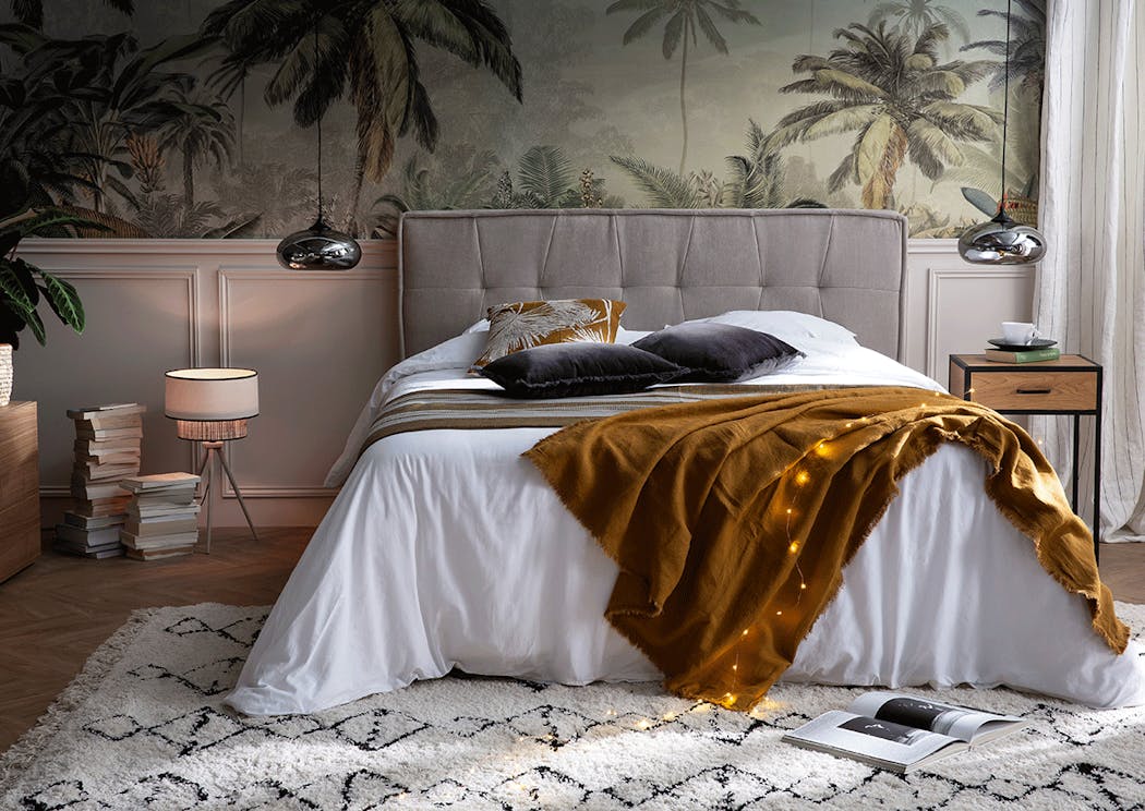 un chambre à coucher avec un papier peint exotique et des suspensions en guise de lampe de chevet