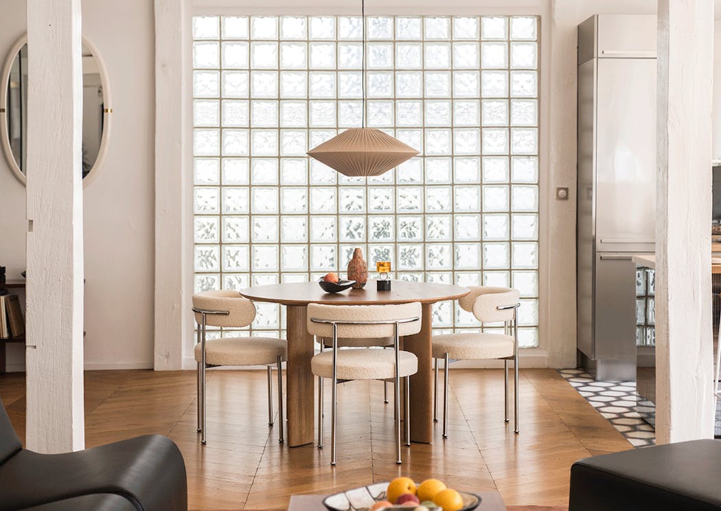 une salle à manger de style scandinave avec une table ronde et des pavés de verre