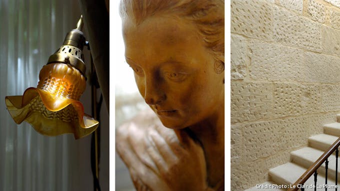 Quelques détails de la déco : une applique en forme de fleur en verre, une statue représentant une femme, un mur de pierre bouchardées.