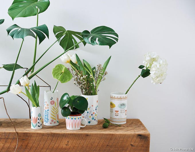 collection de vases et de tasses en porcelaine sur un billot en bois brut
