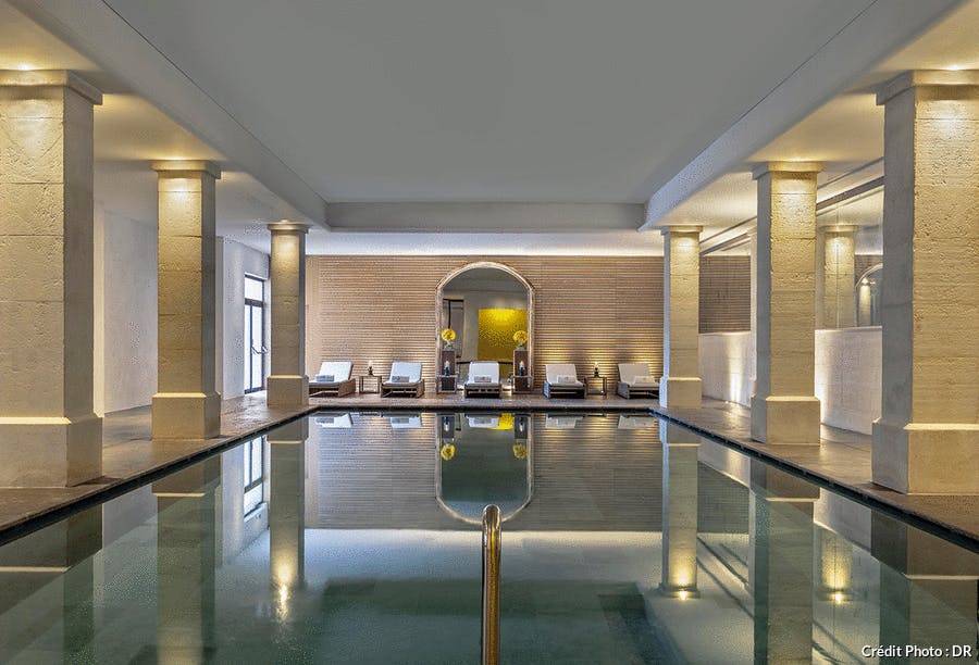 une piscine d'hôtel luxueuse avec des colonnes en pierre