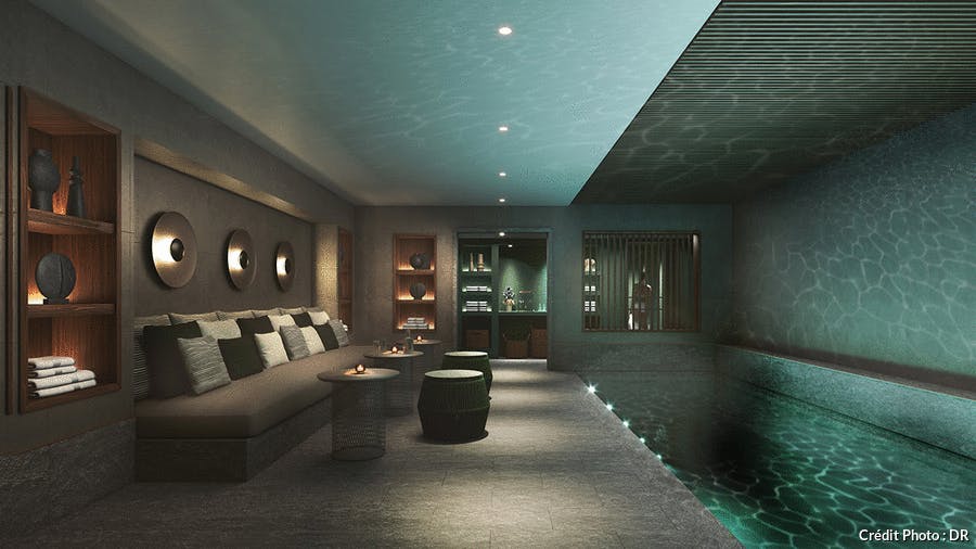 une piscine d'hôtel luxueuse sous-sol avec une lumière tamisée et de la pierre sombre