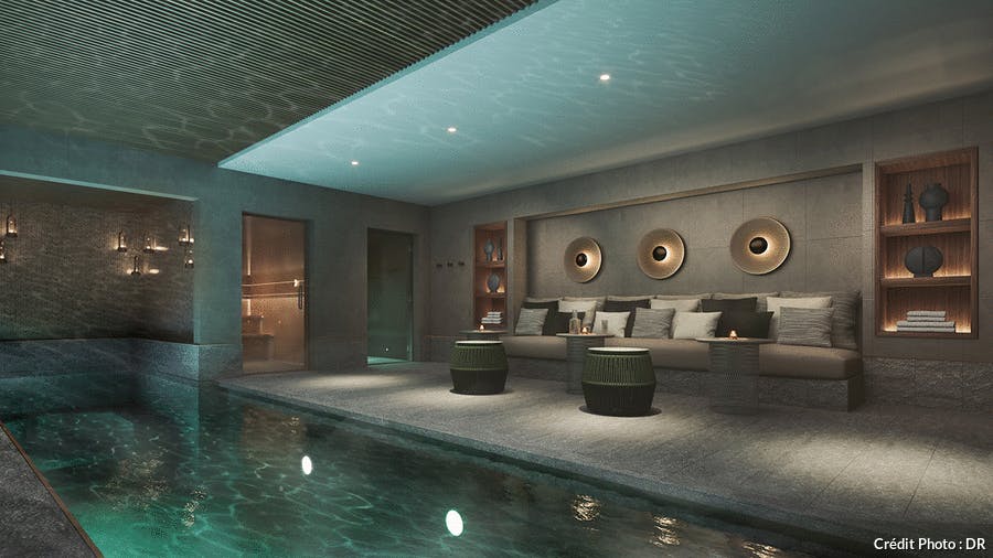 une piscine d'hôtel luxueuse sous-sol avec une lumière tamisée et des banquettes