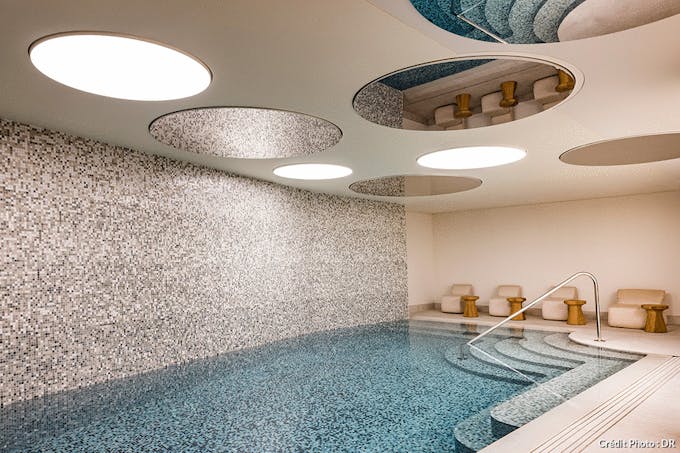 une piscine d'hôtel luxueuse sous-sol avec une de la pierre mouchetée et des lumières circulaires au plafond
