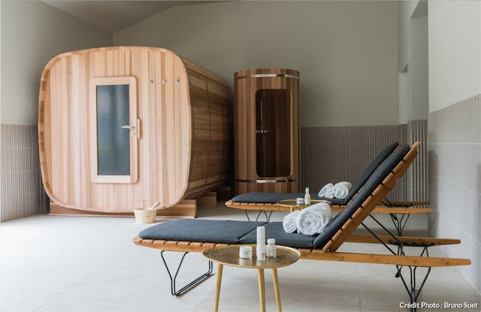 un sauna en bois et une douche minimaliste de style scandinave dans une pièce en béton