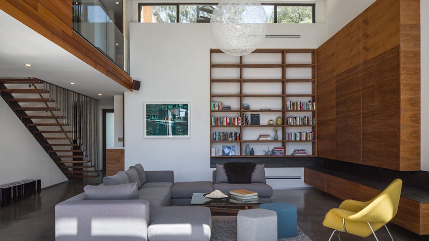 Un salon contemporain avec un canapé d'angle et une mezzanine