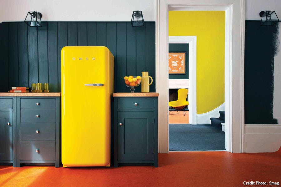 Le réfrigérateur FAB28 jaune dans une cuisine aux tonalités sombres.