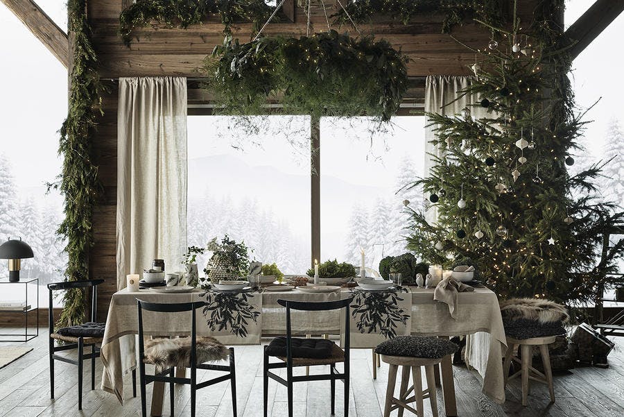 Salle à manger décorée de végétation pour une table de Noël naturelle