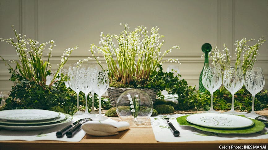 une table de fête dressée avec des compositions florale à base de muguet