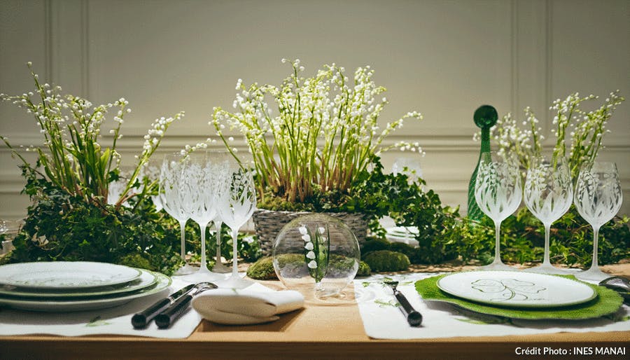 une table de fête dressée avec des compositions florale à base de muguet