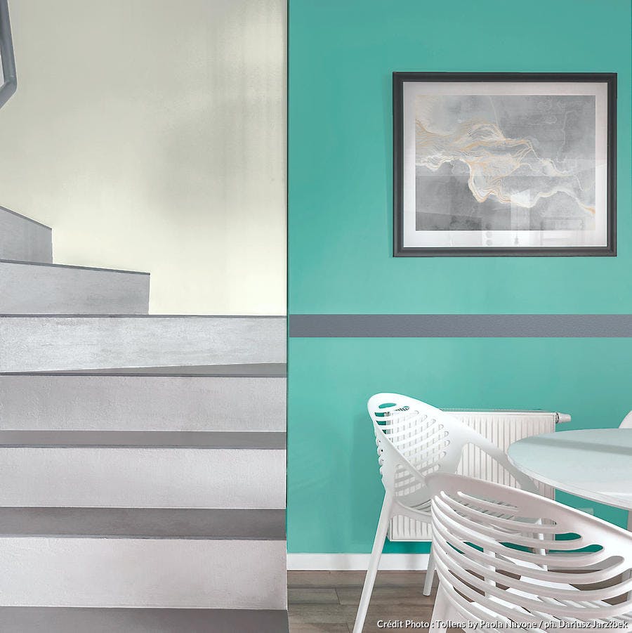 chaise et table avec mur vert et escalier en beton gris