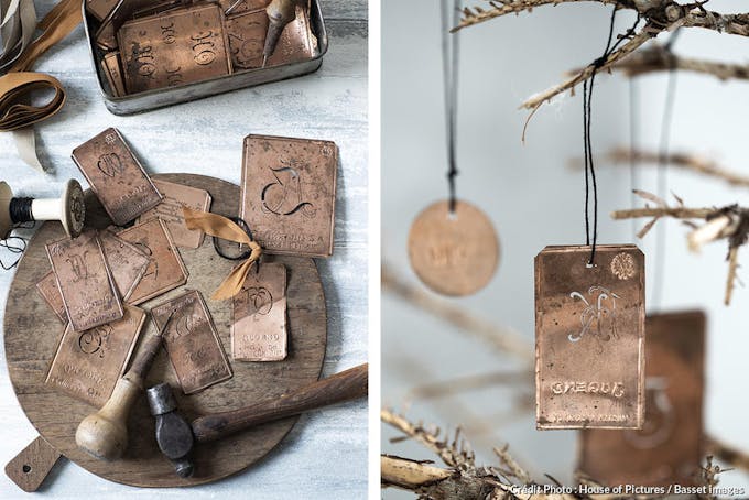 Un marteau et des des étiquettes en cuivre pour fabriquer des décorations de Noël