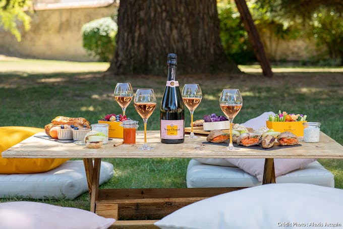 Déjeuner sur l'herbe sous forme de pique nique champêtre luxueux avec crudités et fruits du jardin et du champagne rosé Veuve Clicquot. 